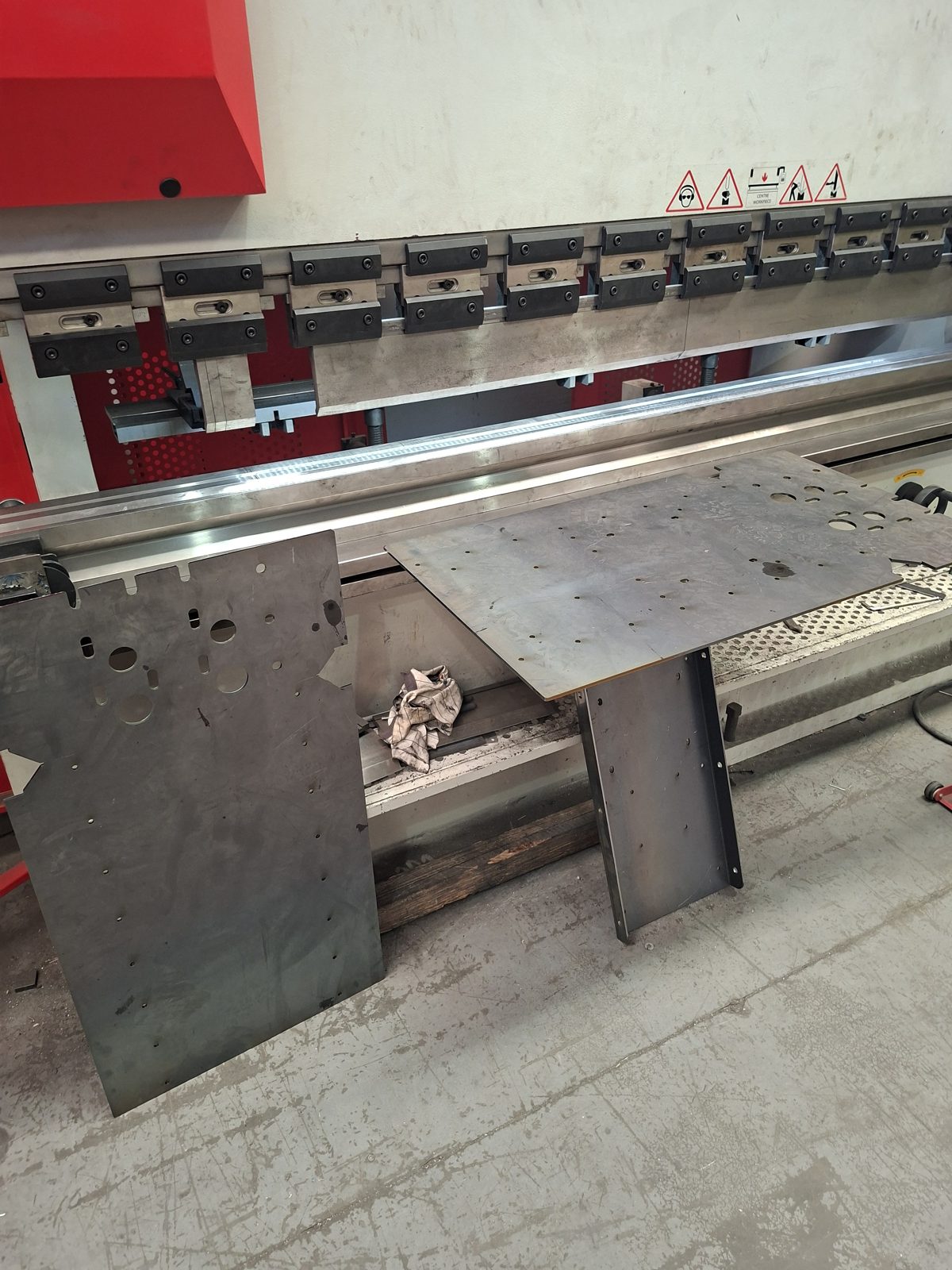 Steel plates on the bed of a CNC press brake