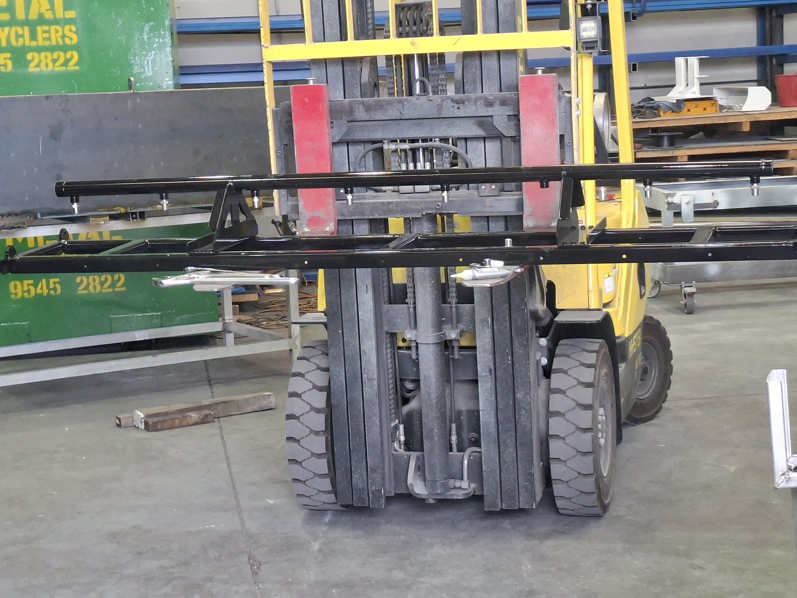 A forklift carrying the painted lower spray bar