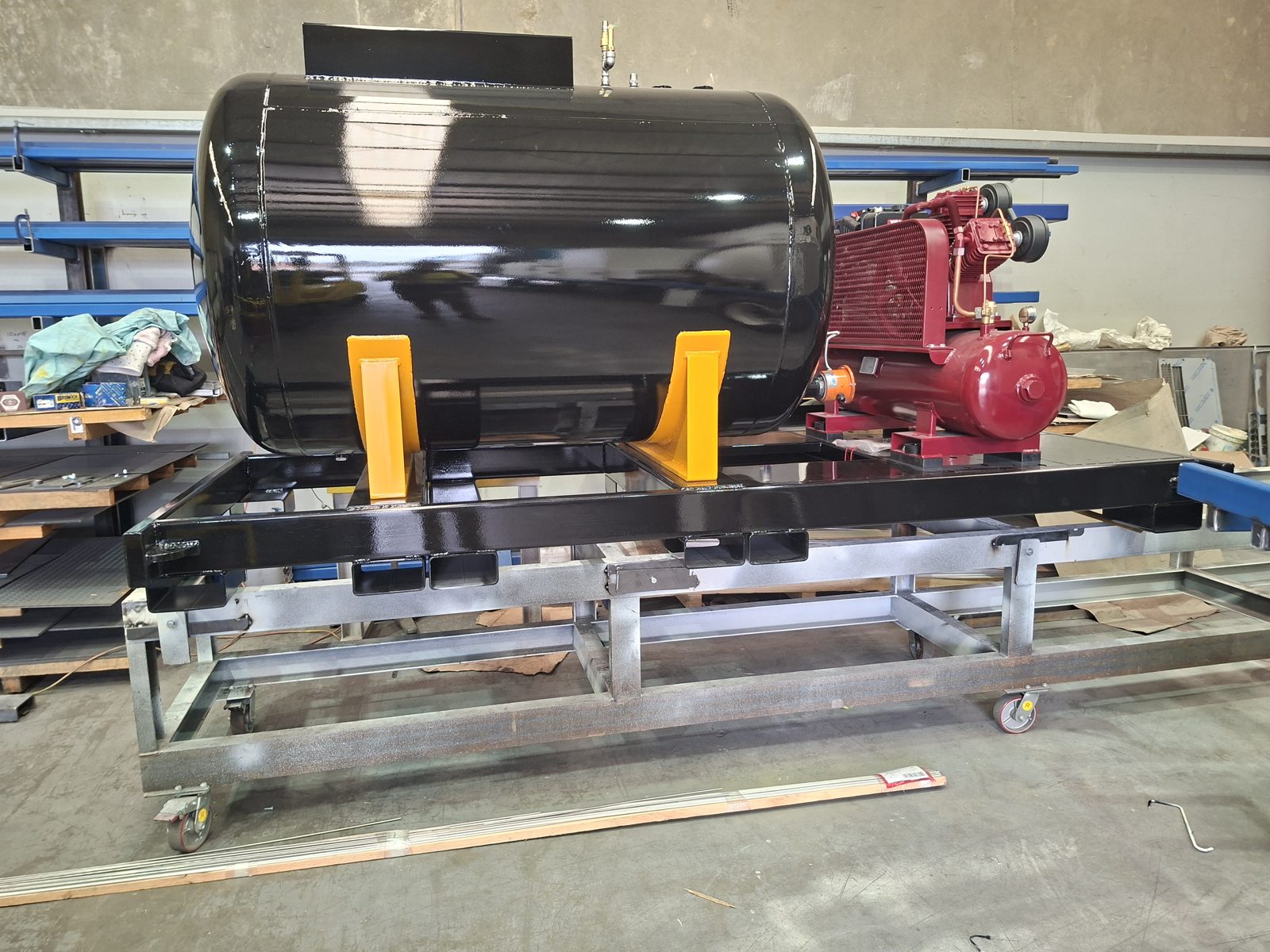 A black tank and red pump on a steel frame, a finished subassembly